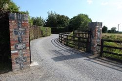 Driveway with chipped limestone and electric gates.